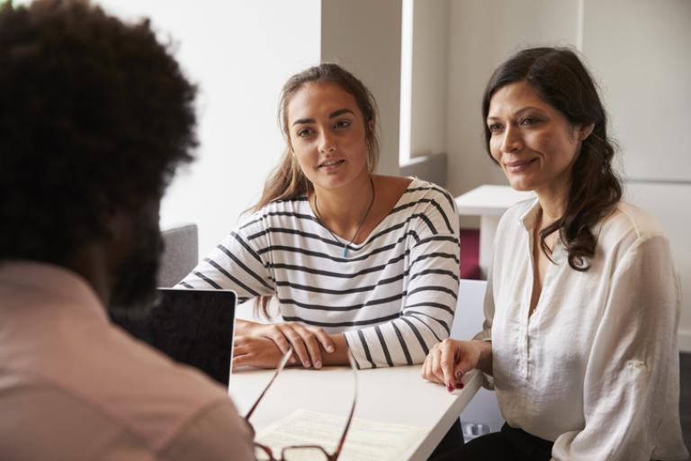 Image of 3 people at a desk meeting
